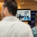 Employees watching a live demonstration of an AI-powered, video-based ergonomic assessment.