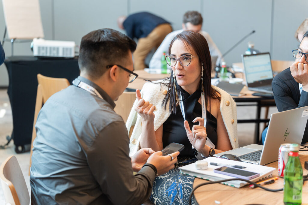 EHS professionals seated in front of a laptop chatting about audit results they are examining from their EHS Management software
