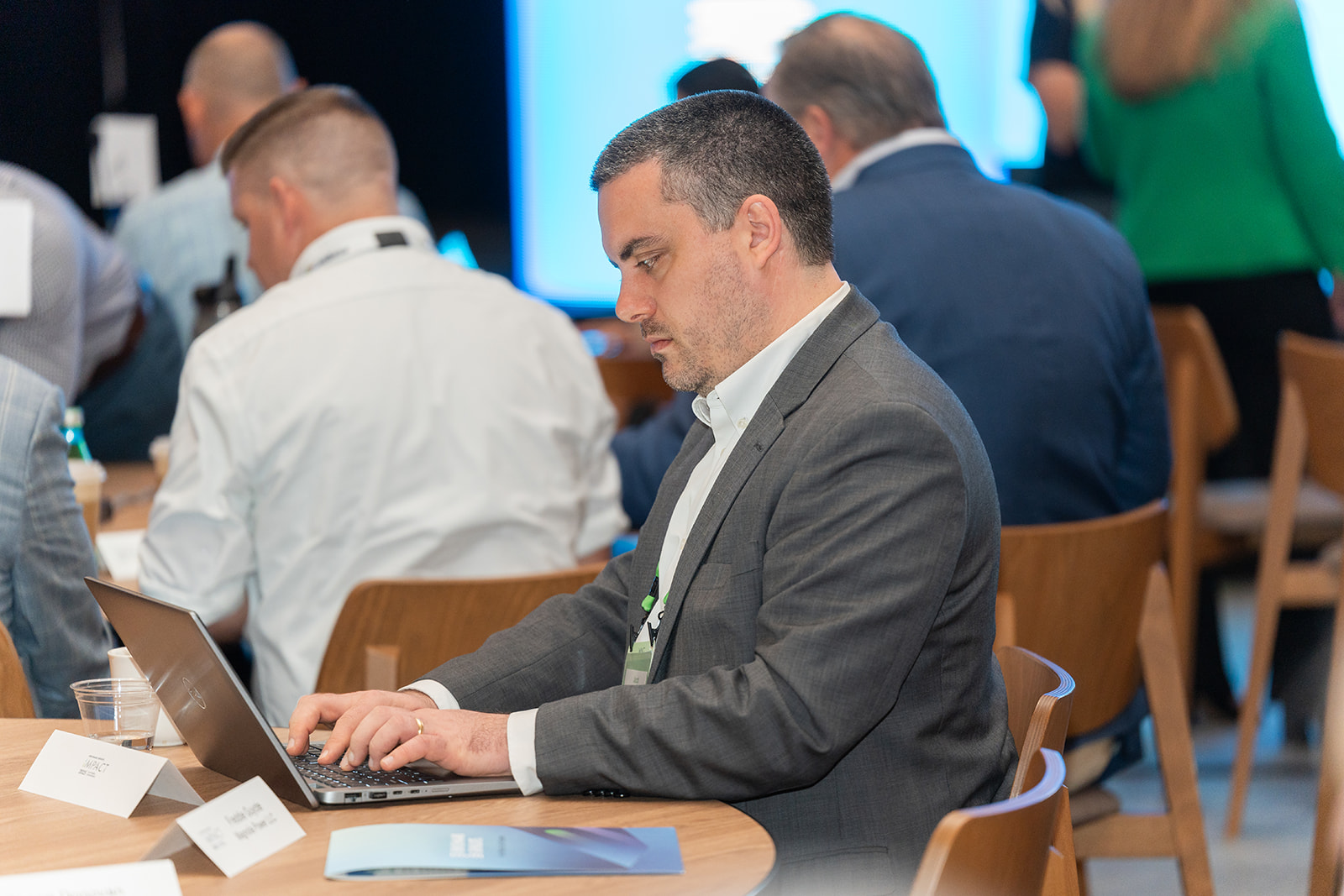 Sustainability executive seated in front of a laptop at Benchmark Gensuite's 2025 Impact conference for subscribers