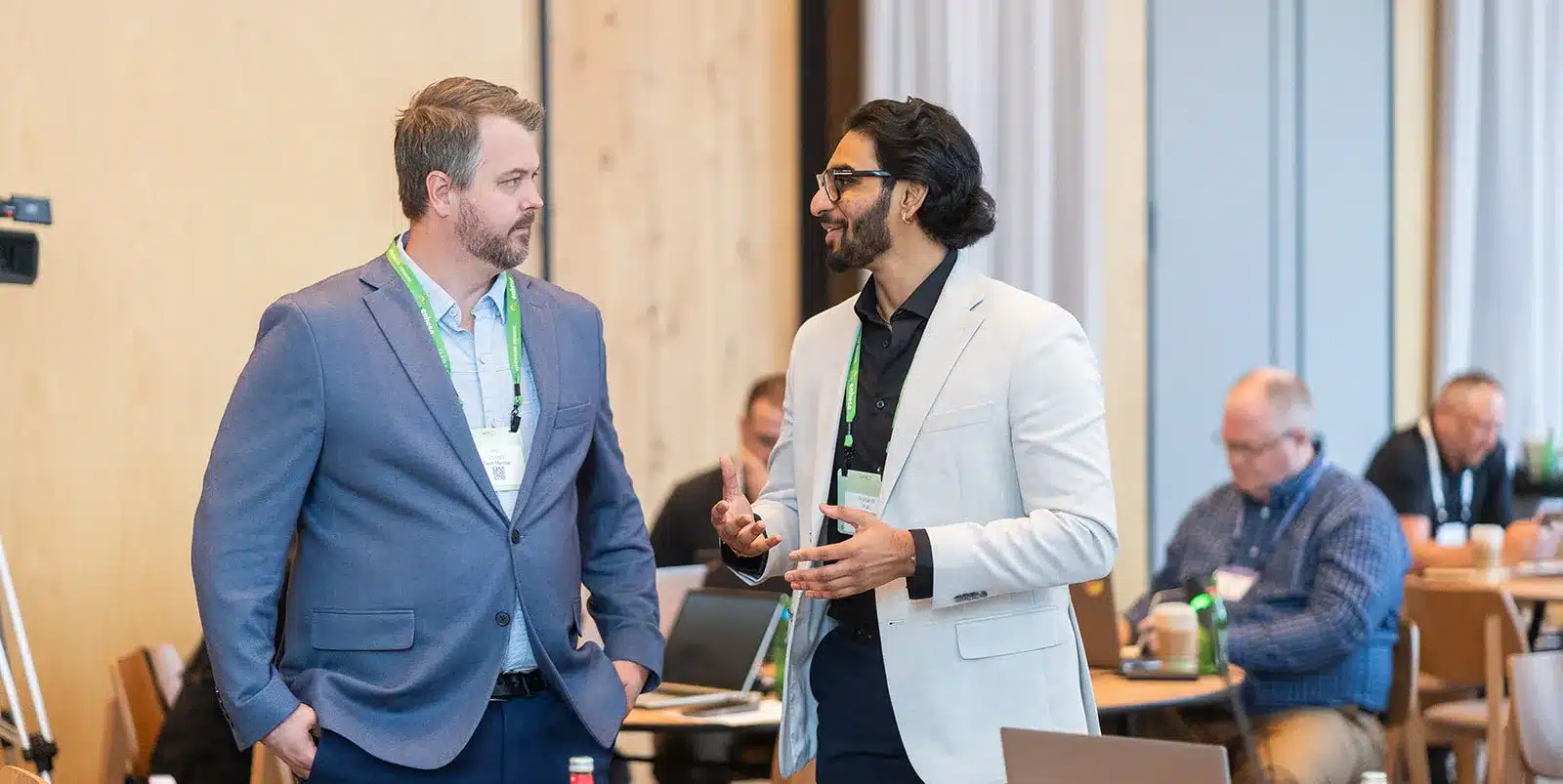 2 males talking in the Impact customer conference 2025