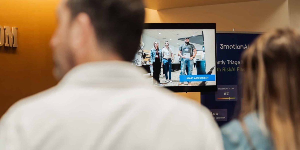 Employees watching a live demonstration of an AI-powered, video-based ergonomic assessment.