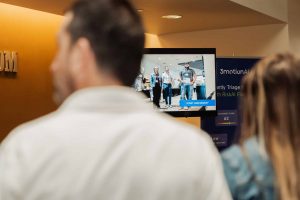 Employees watching a live demonstration of an AI-powered, video-based ergonomic assessment.